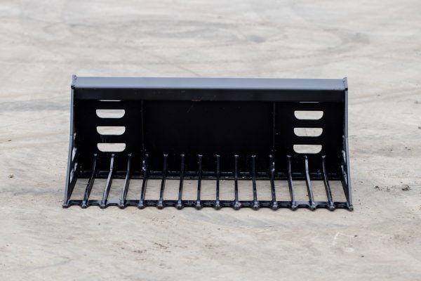 A black bucket with holes in it is sitting on the ground