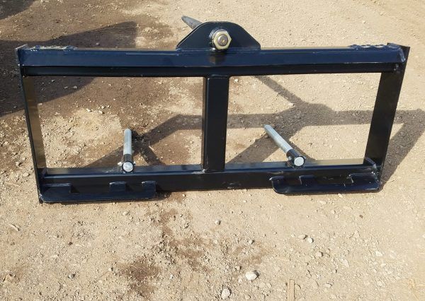 A hay bale spike attached to a forklift on a white background.