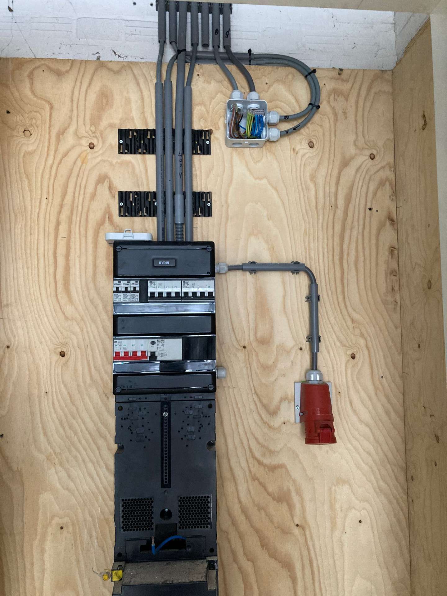 Een houten muur waar een heleboel draden uit komen