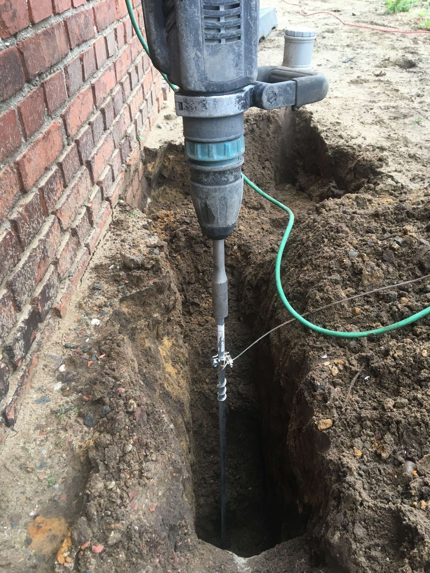 Er wordt gebruik gemaakt van een boormachine om een ​​gat in de grond te boren.