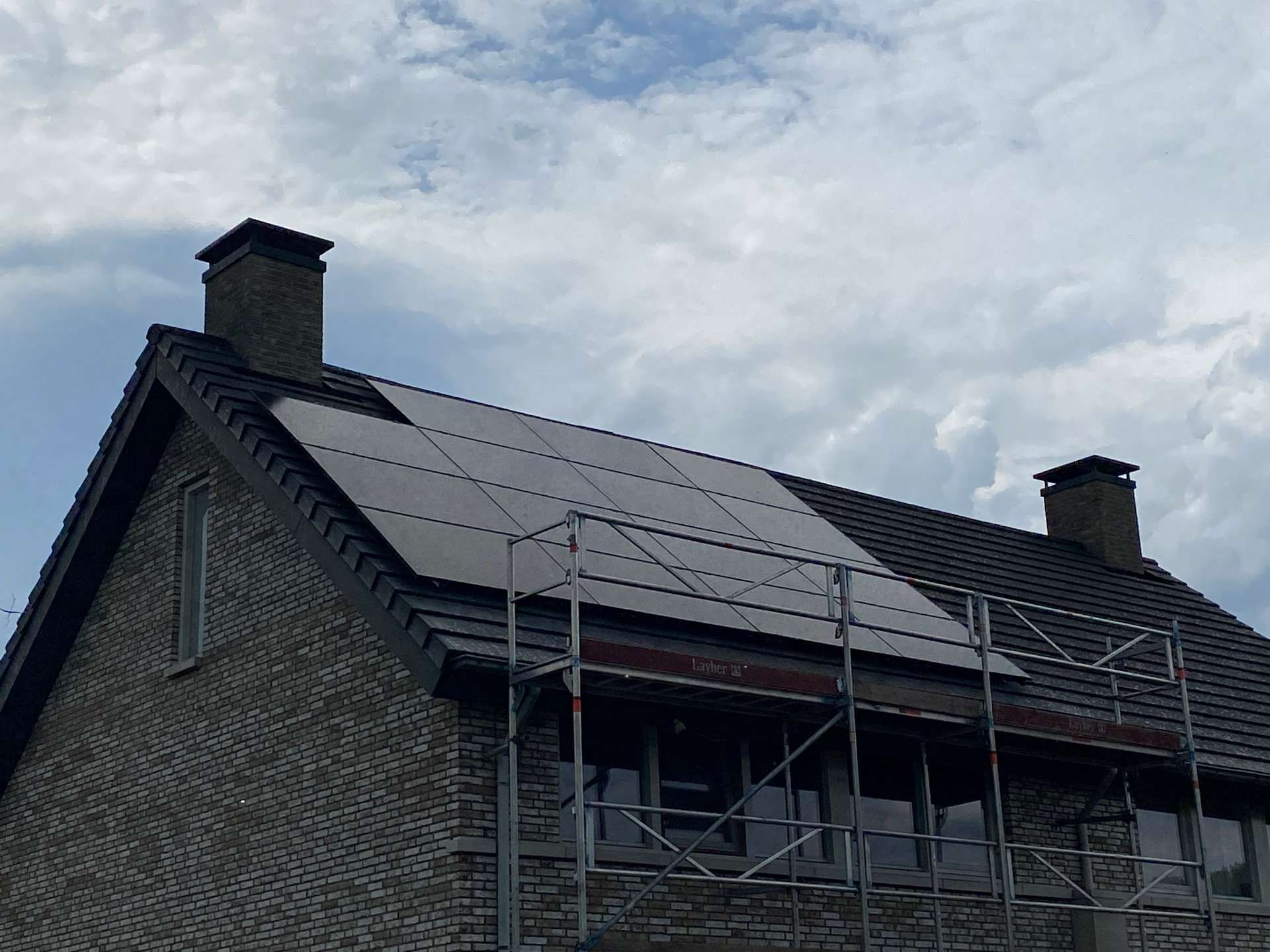 Een bakstenen huis met zonnepanelen op het dak