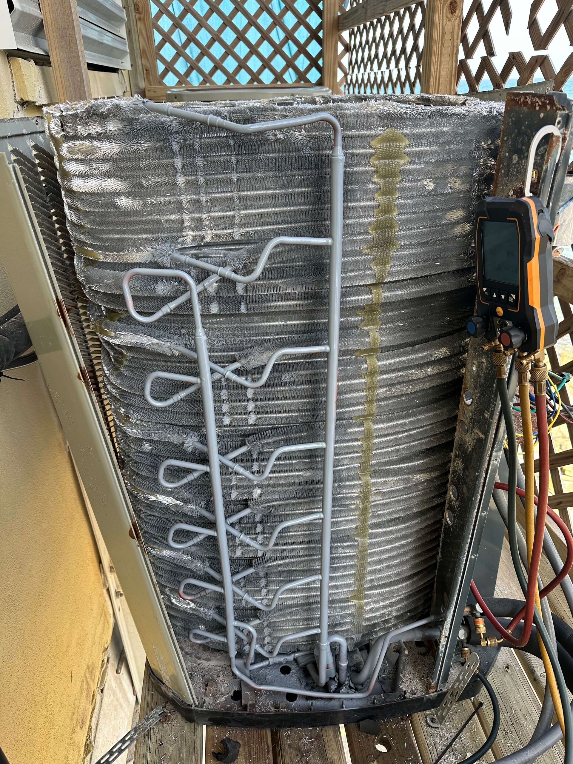 A dirty air conditioner is sitting on top of a wooden table.
