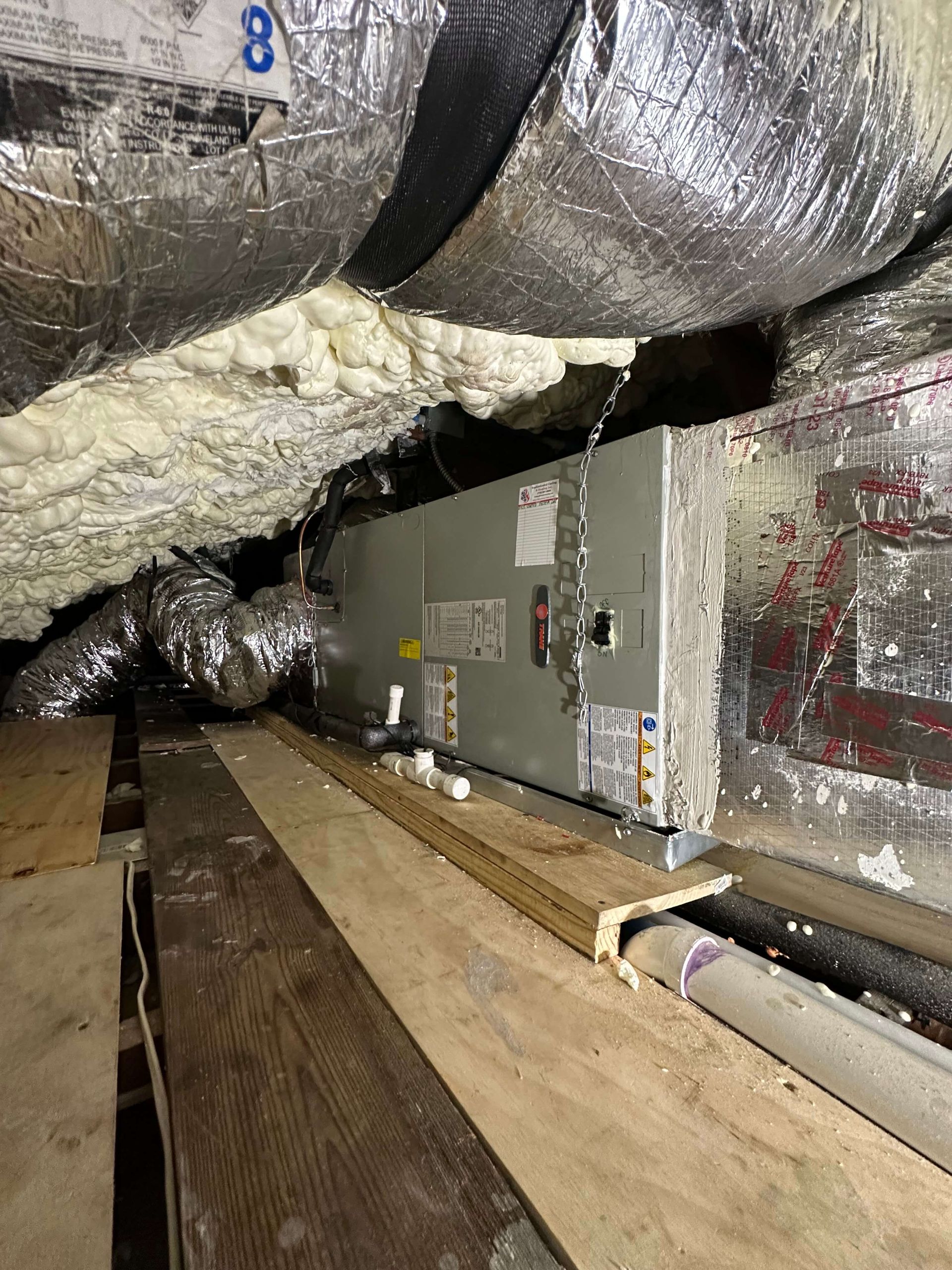 An air conditioner is sitting under a ceiling in a room.