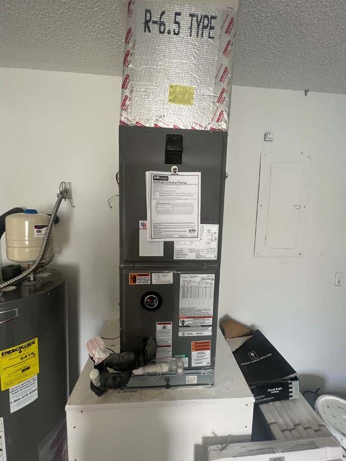 A r-6.5 type air conditioner is sitting in a room next to a water heater