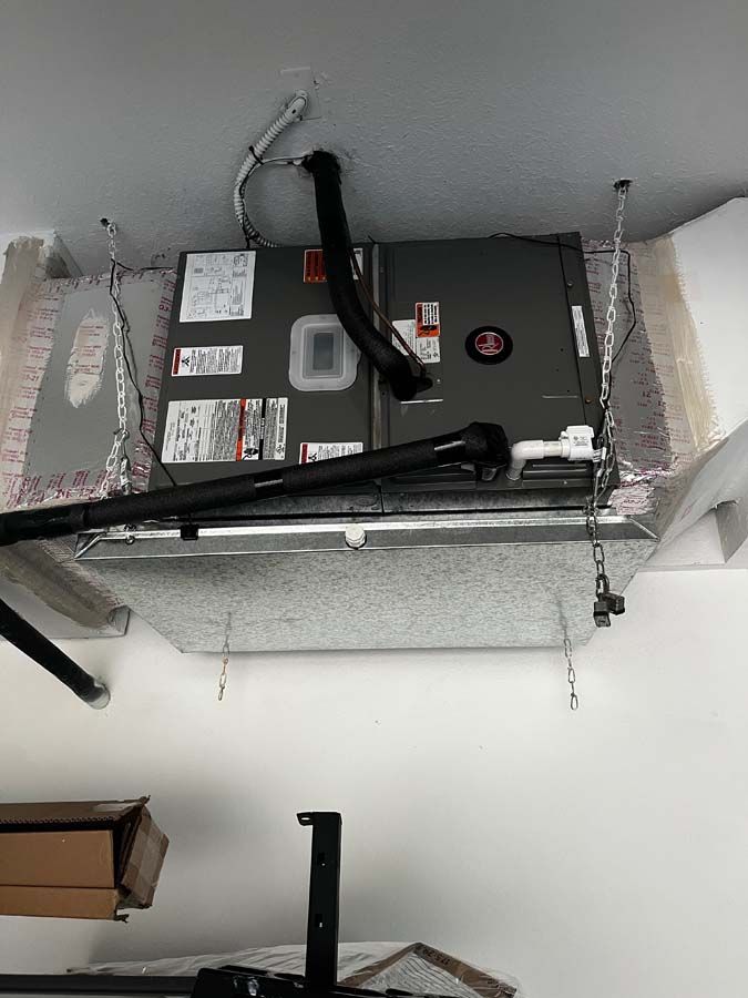 An air conditioner is hanging from the ceiling of a room.