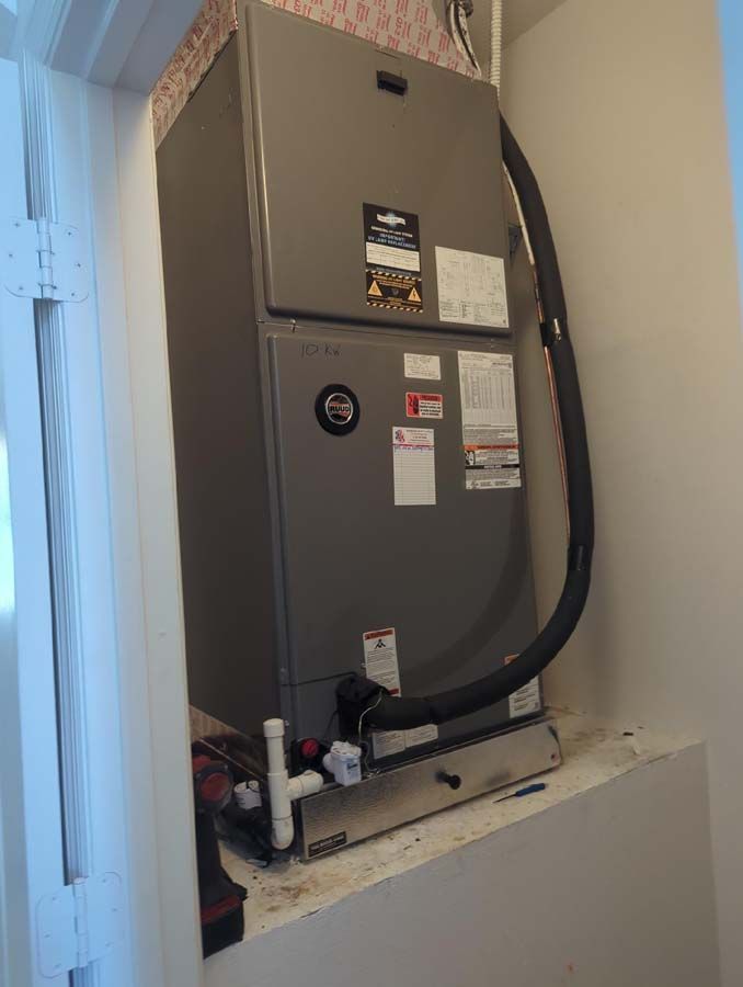 An air conditioner is sitting on a shelf in a room.