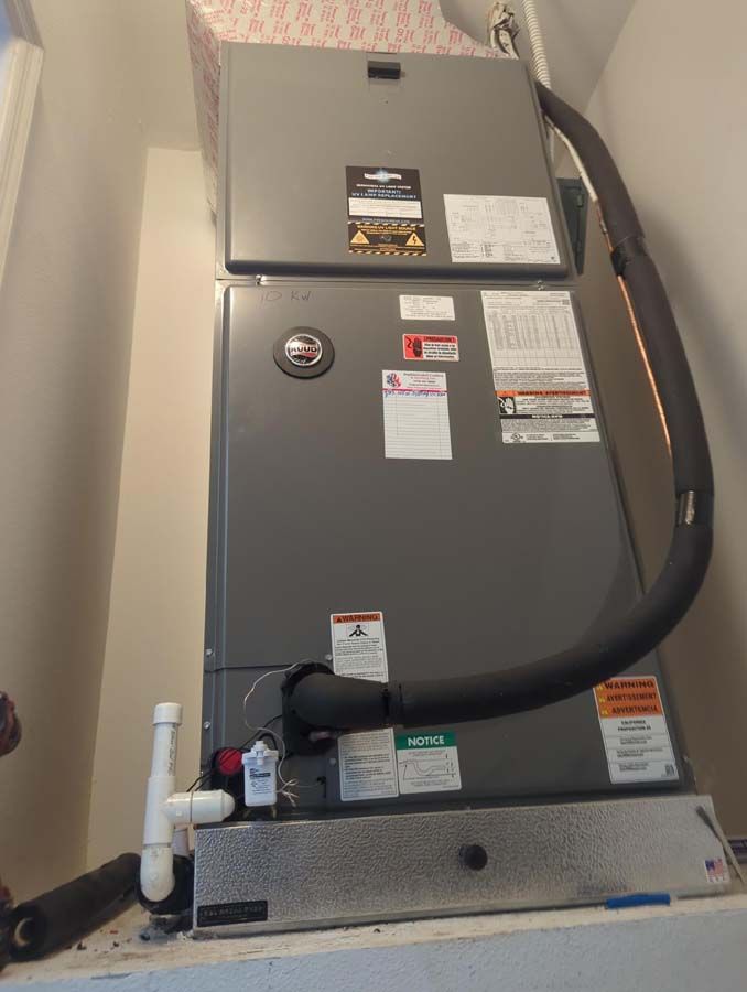 Two air conditioners are sitting on top of each other in a room.