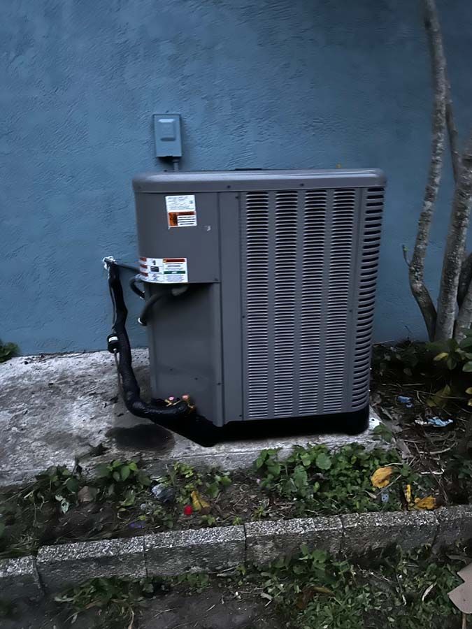 A large air conditioner is sitting on the side of a building.