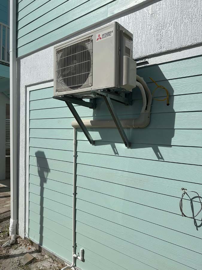 A mitsubishi air conditioner is mounted on the side of a building.