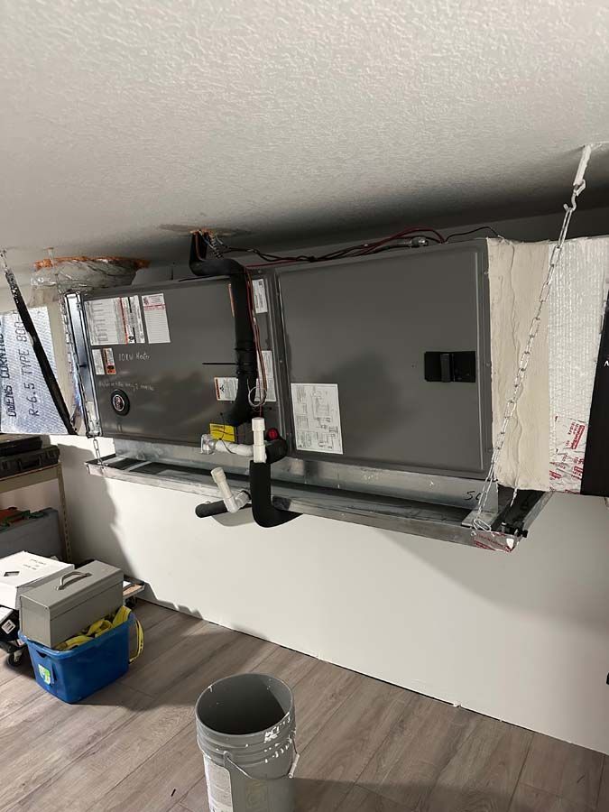 A room with a ceiling fan and a bucket on the floor.