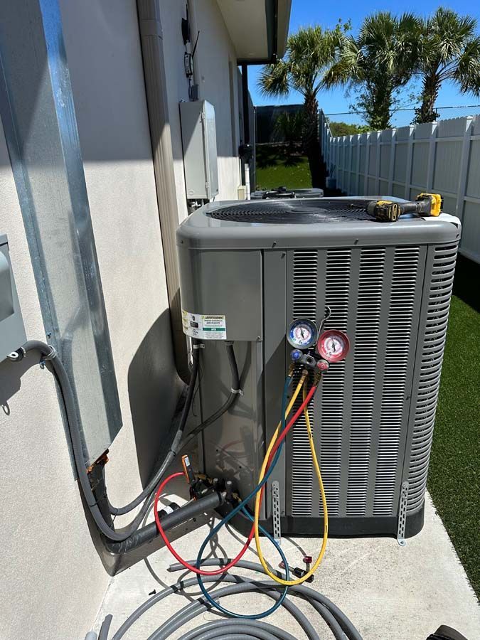 An air conditioner is being installed on the side of a house.