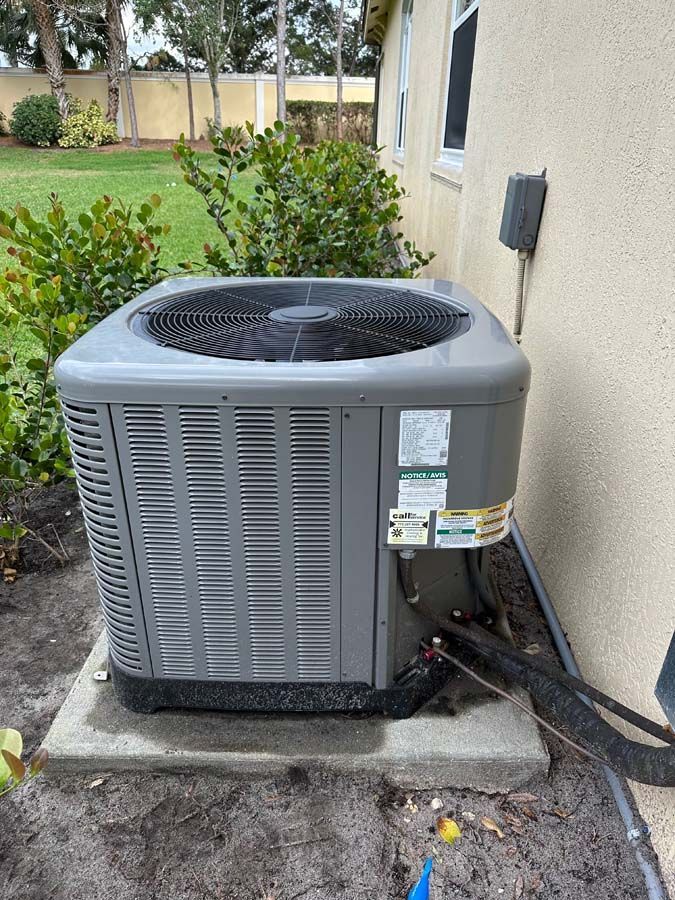 An air conditioner is sitting on the side of a house.