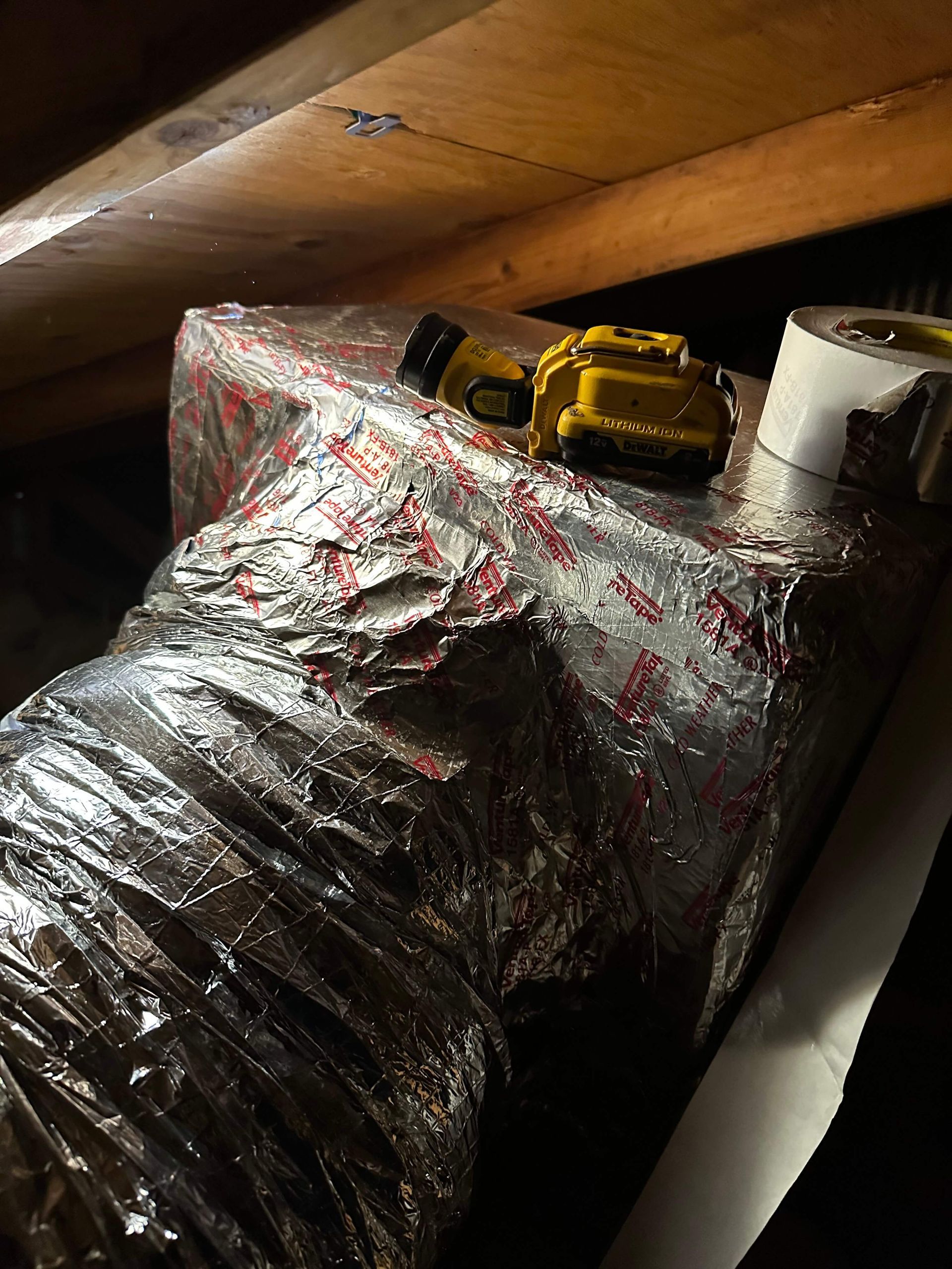 A yellow tape measure is sitting on top of a piece of aluminum foil.