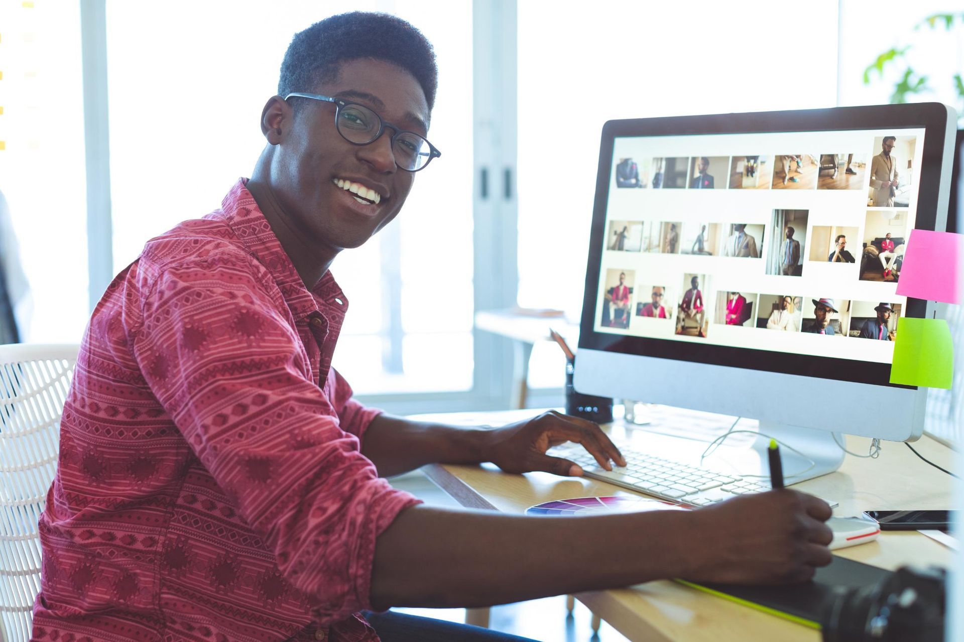 Man smiling at computer with photo editing software.