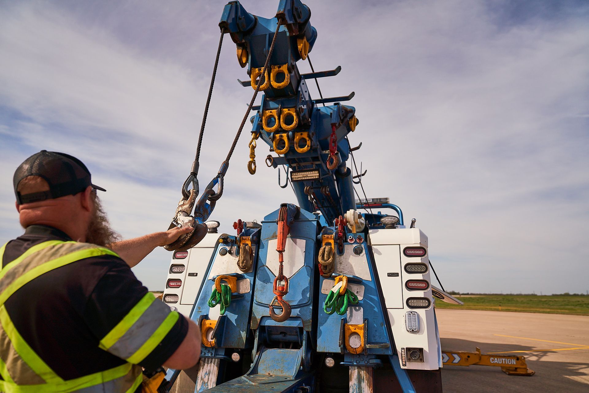 Tow truck parked outside a gray building with the business name 