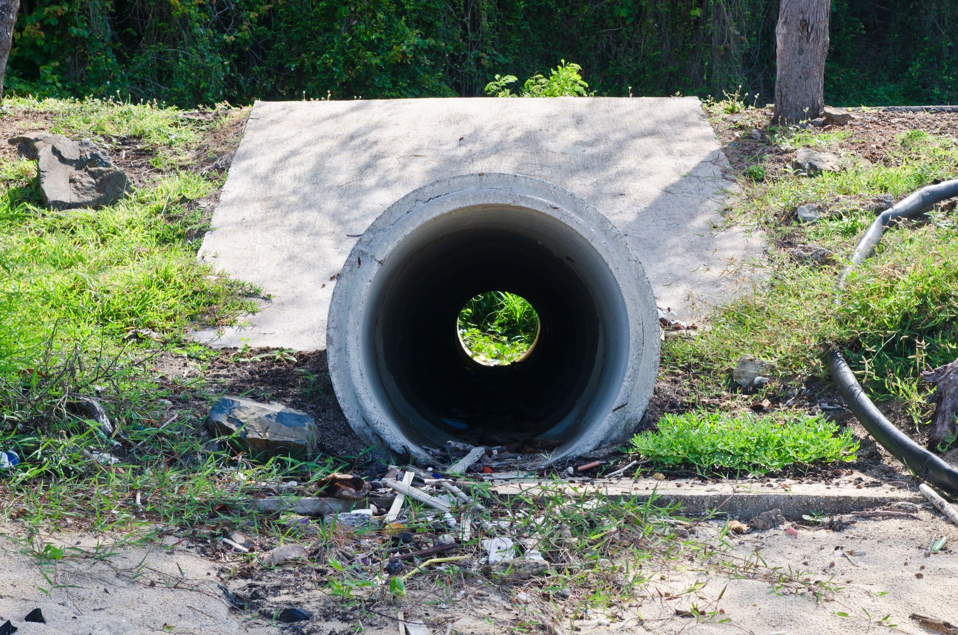 A leach field for a septic system with rows of black plastic drain covers resting on sand, connected to a central junction.