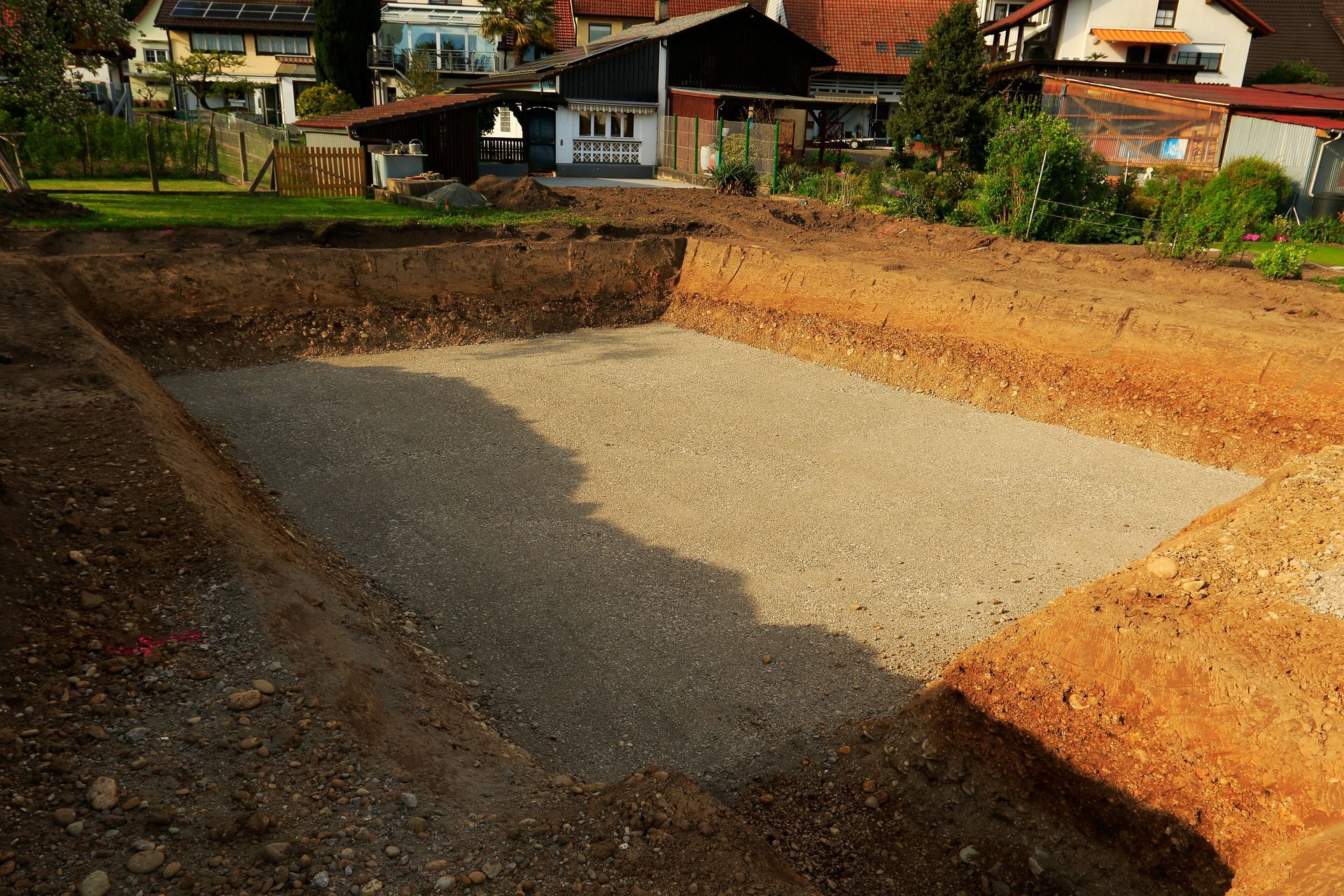 A series of cylindrical concrete utility structures partially buried in a dirt construction trench.