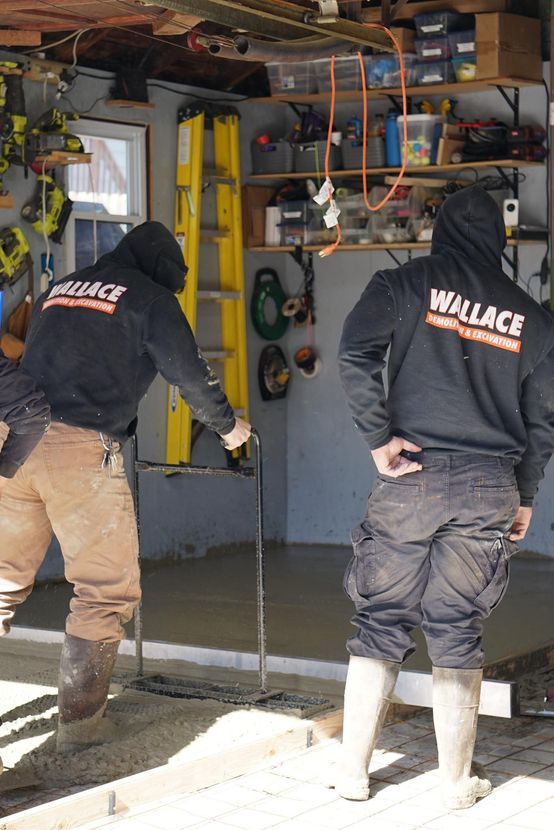 Two men wearing willace sweatshirts are working in a garage