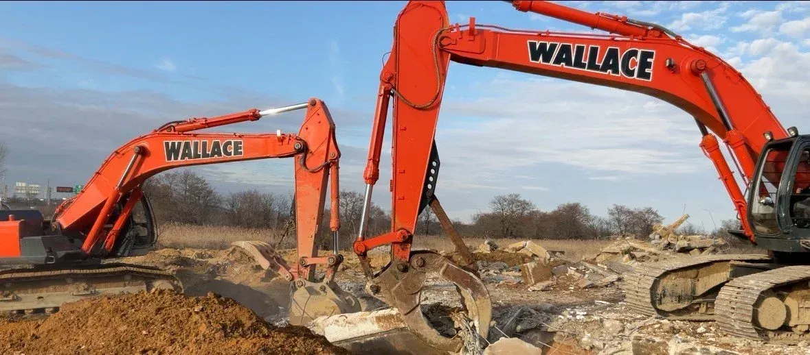 An orange excavator with a large bucket on a white background.