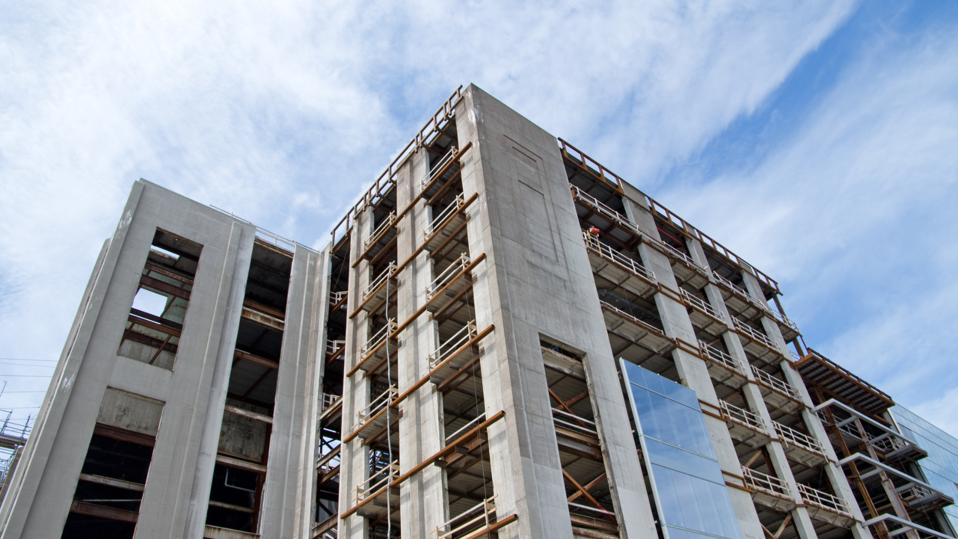 A large building under construction with a blue sky in the background.