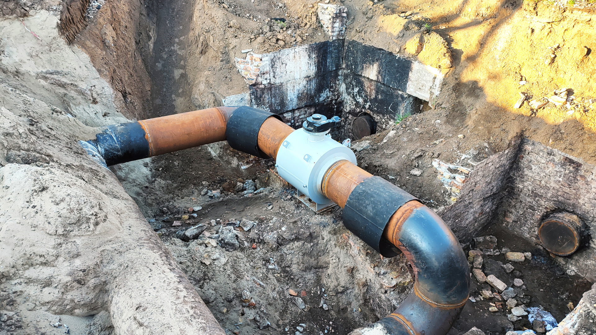 A pipe is being installed in a hole in the ground.