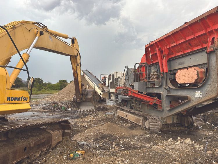 A yellow komatsu excavator is moving dirt next to a red and gray machine.