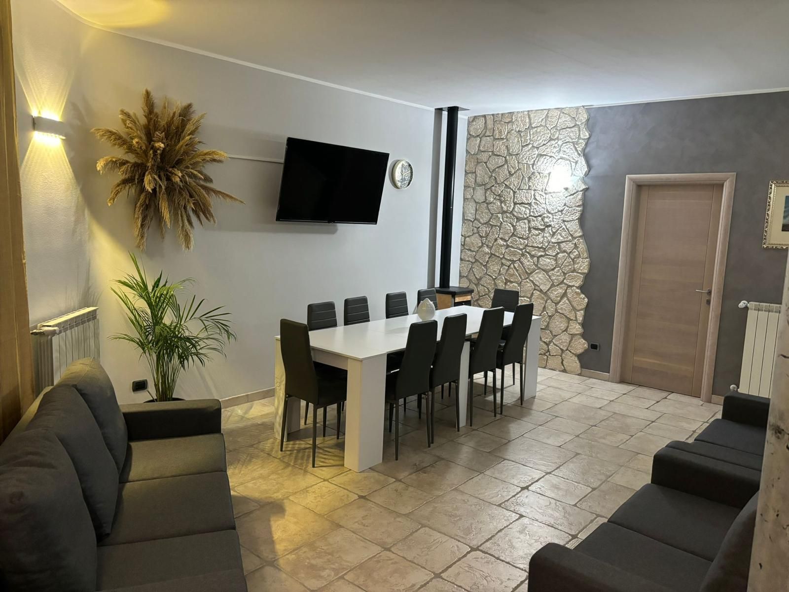 Un soggiorno con tavolo da pranzo, sedie e TV a schermo piatto.