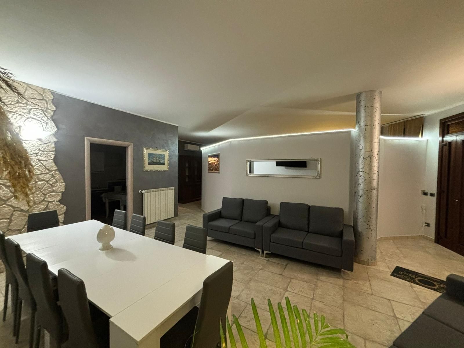 Un soggiorno con un lungo tavolo, sedie e un divano.