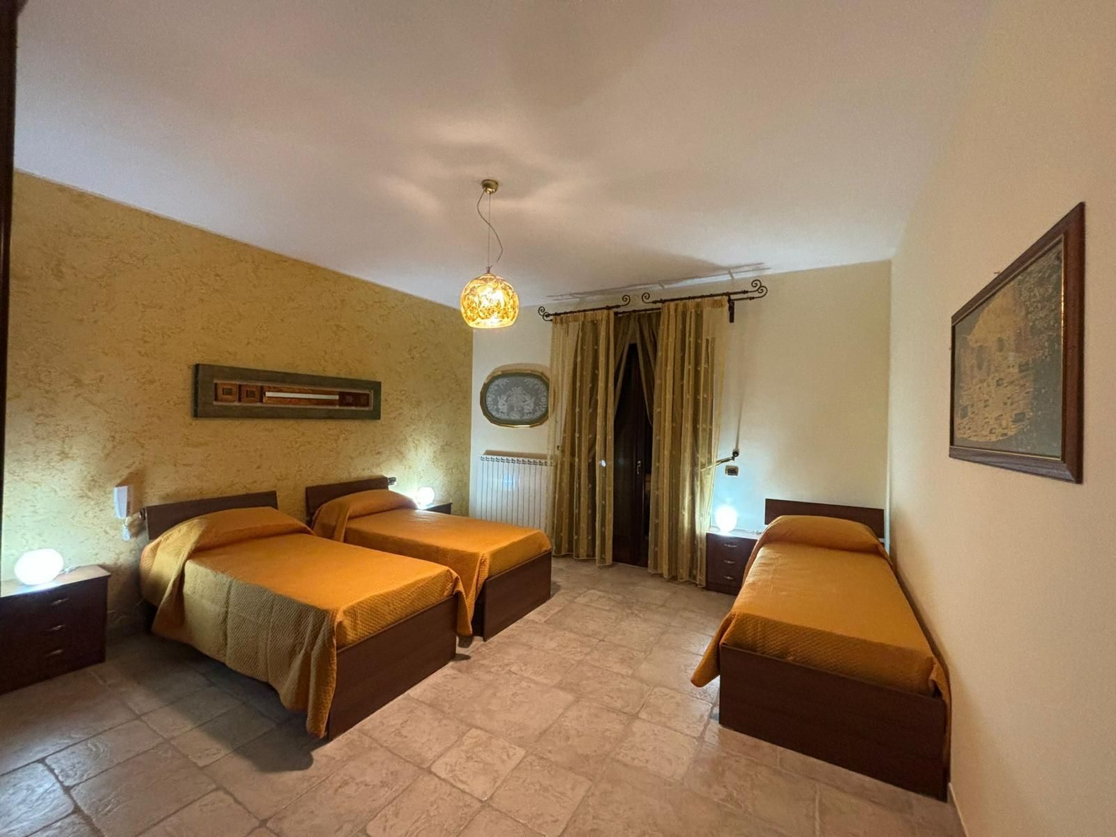 Una camera da letto con tre letti e un quadro alla parete.