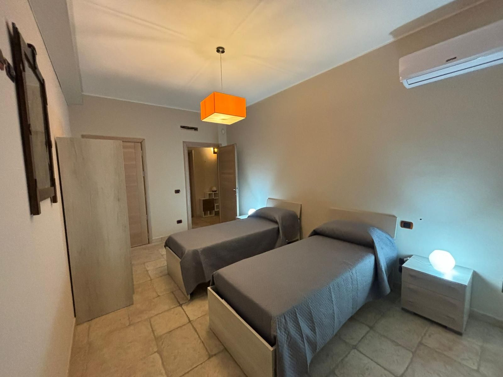 Una camera da letto con due letti singoli e un comodino.