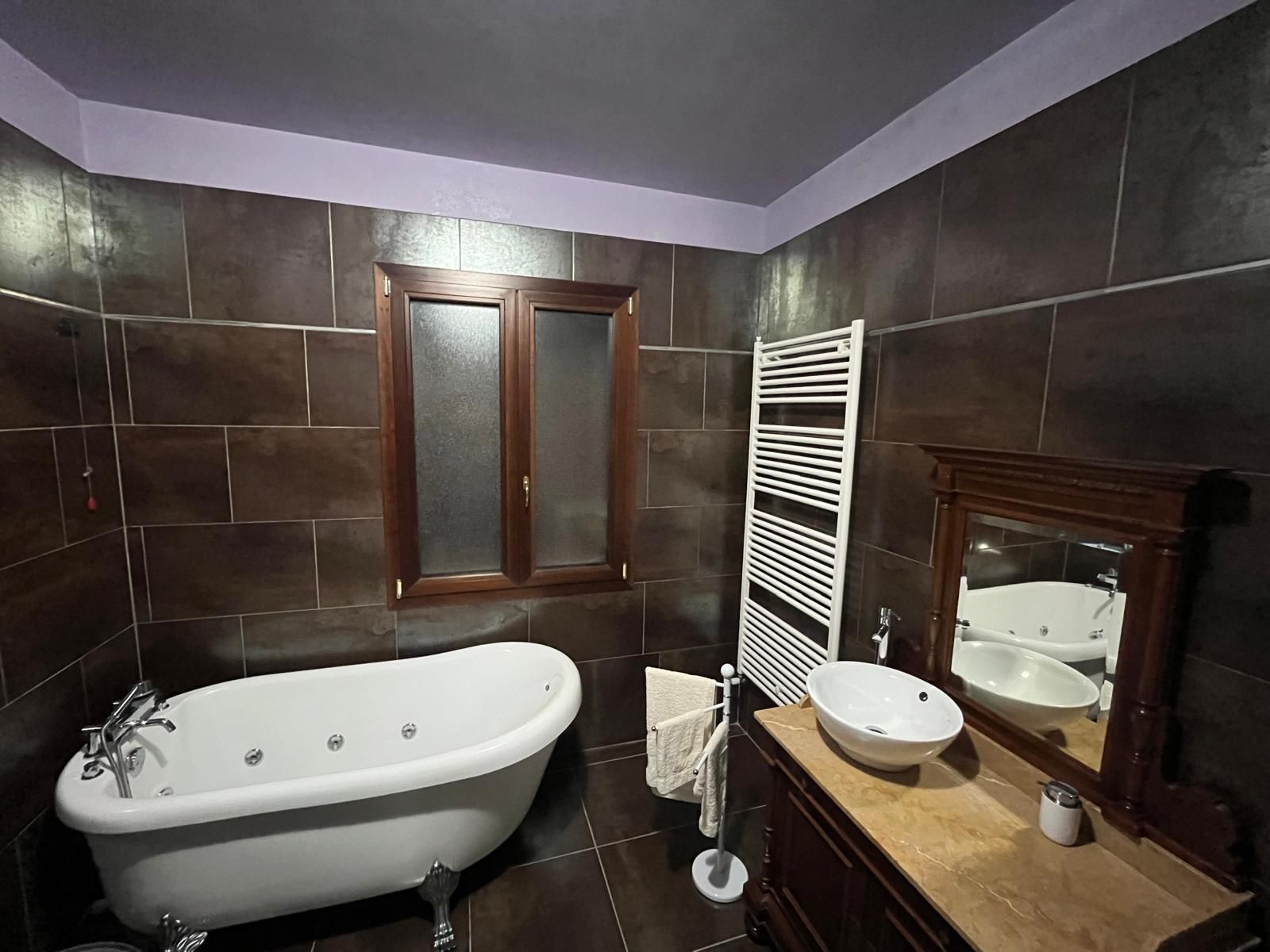 Un bagno con vasca, lavandino e specchio