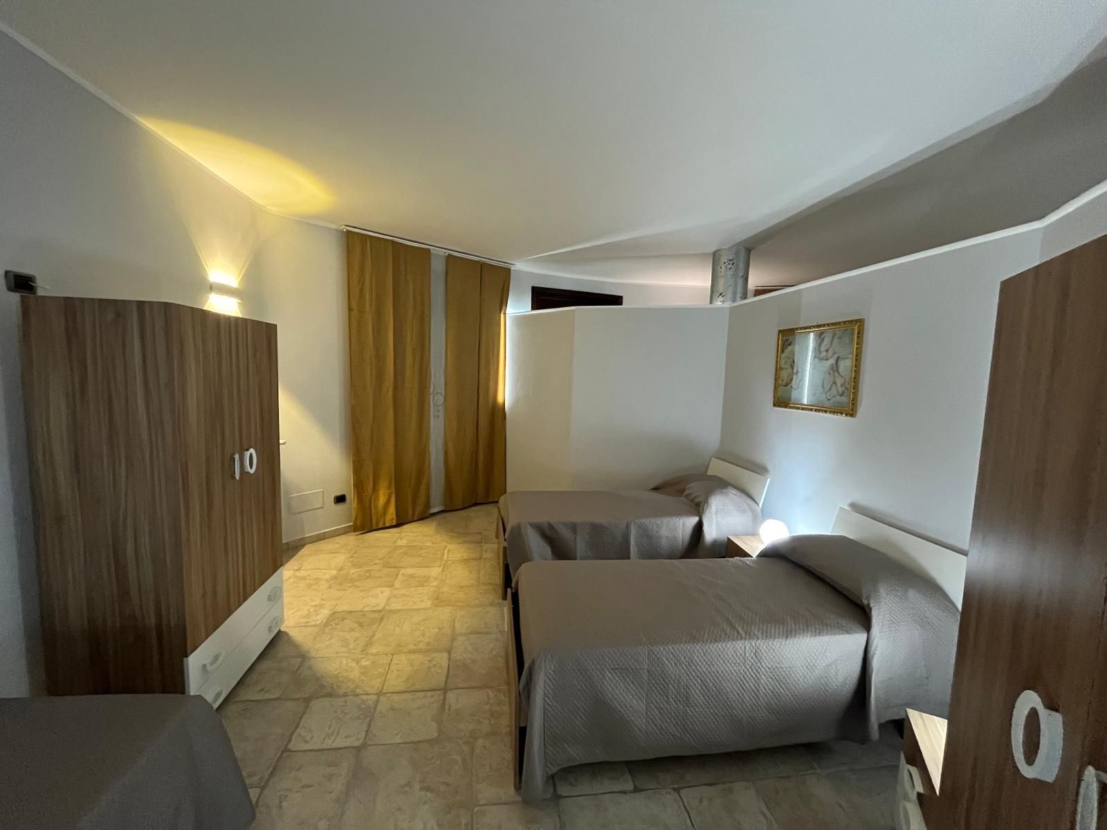 Una camera da letto con tre letti e una finestra.