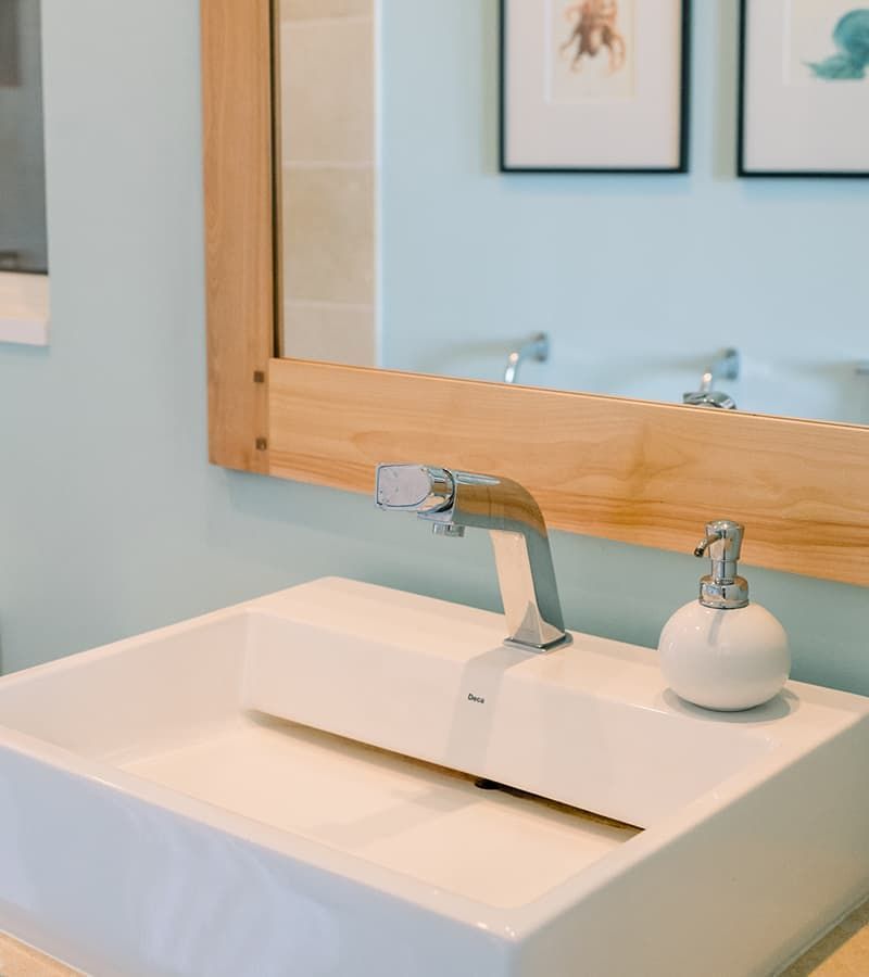 White sink with chrome faucet and white soap dispenser