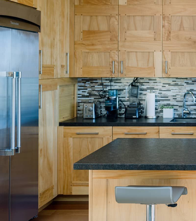 Stainless steel refrigerator and light wood cabinets
