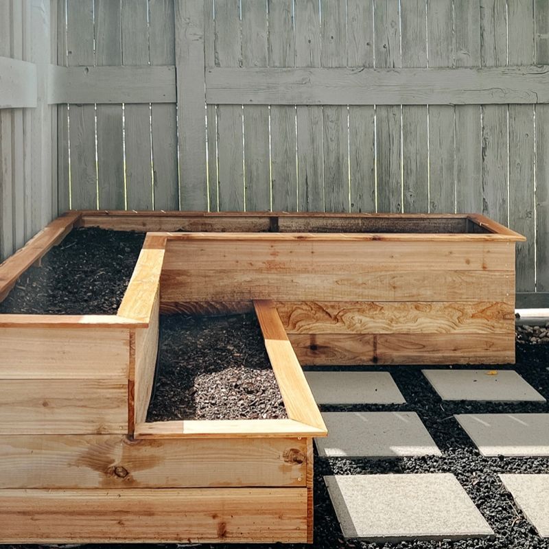 Wooden raised garden beds filled with dark soil