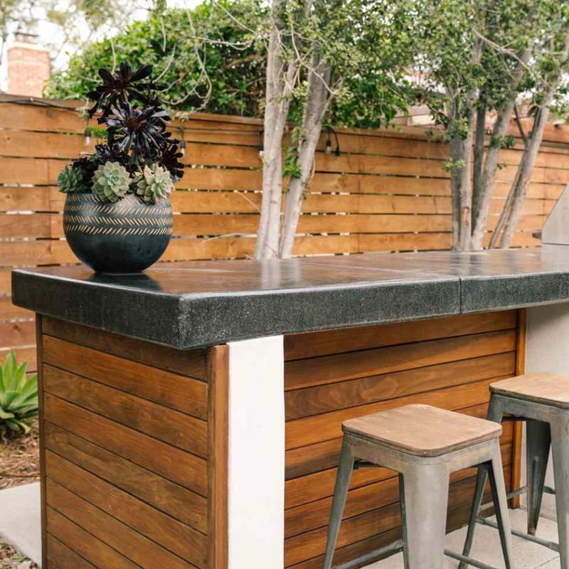 Outdoor bar with a wooden base and dark countertop