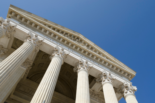 A family hiking on a trail. A child in a yellow jacket leads, followed by a group of people in winter clothes.