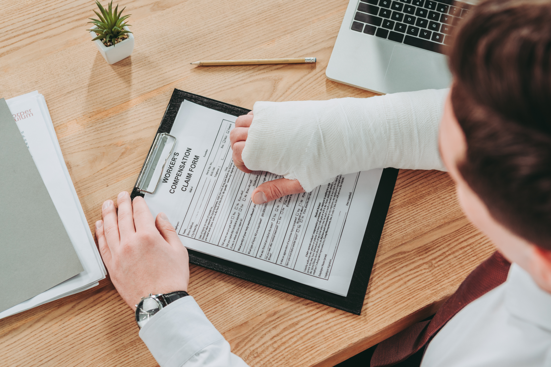 Older man with beard signing document, woman smiles beside him at a table.