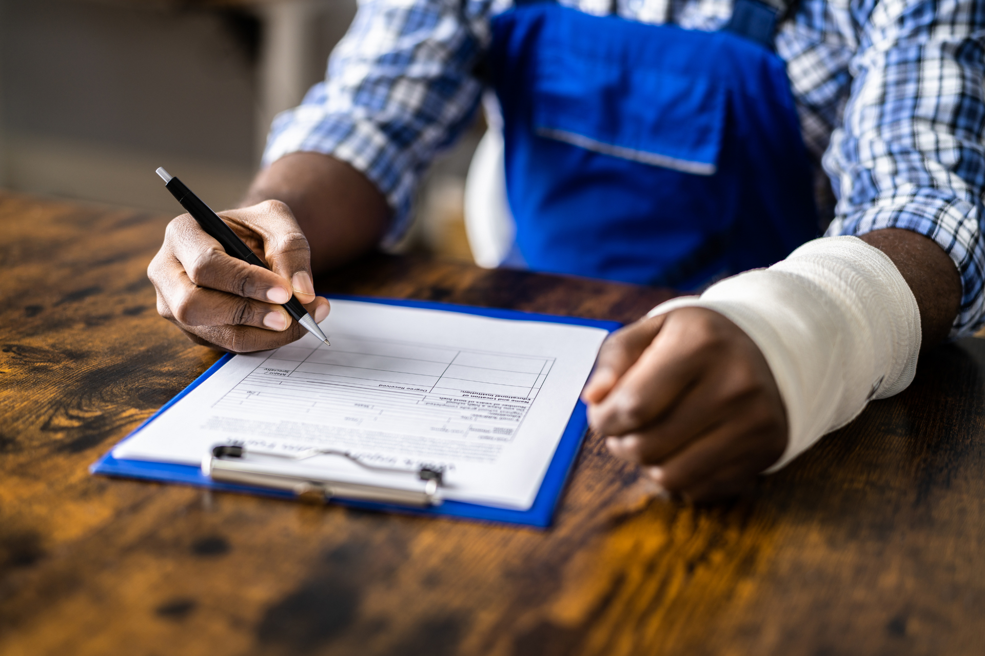 Older man with beard signing document, woman smiles beside him at a table.