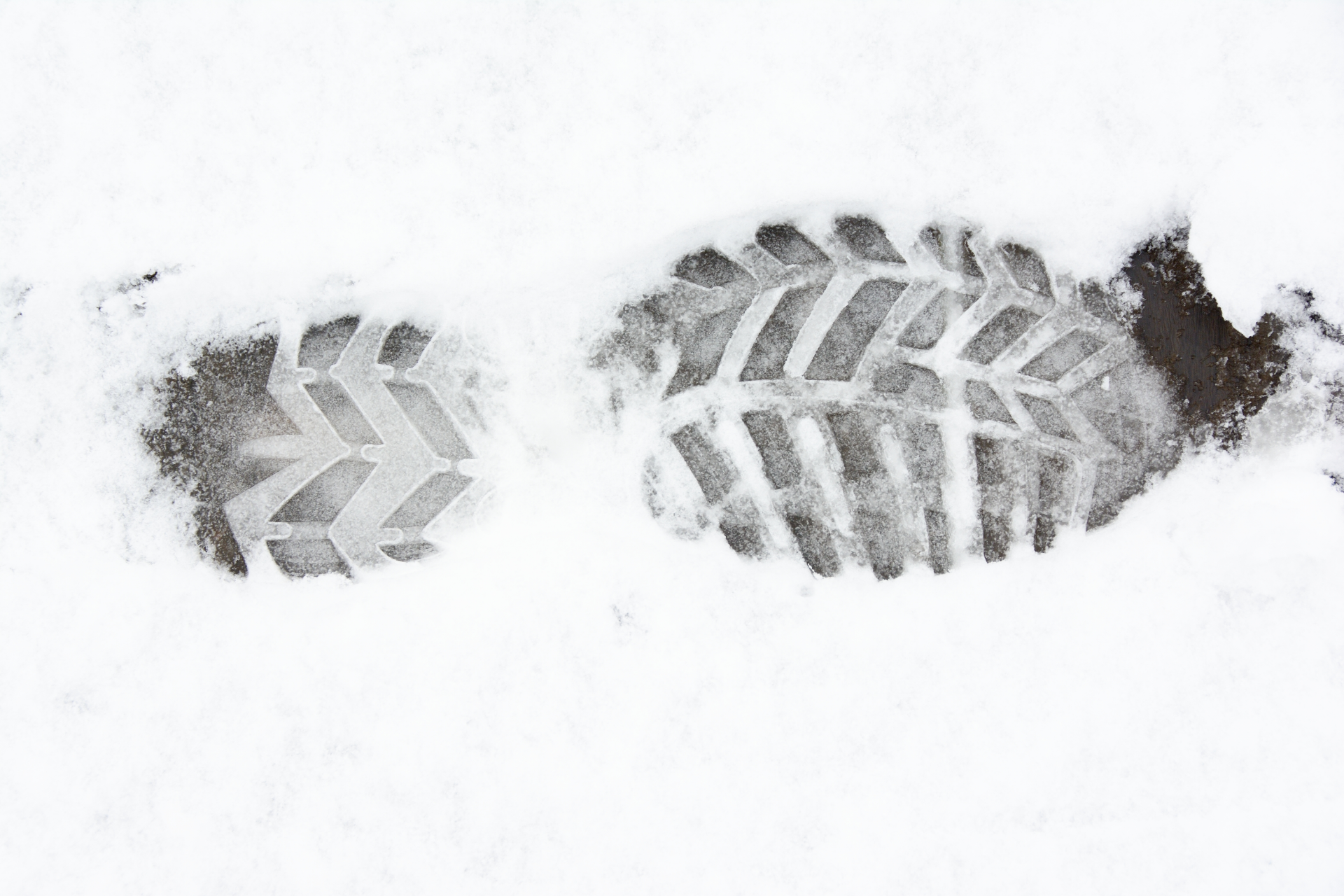Older man with beard signing document, woman smiles beside him at a table.