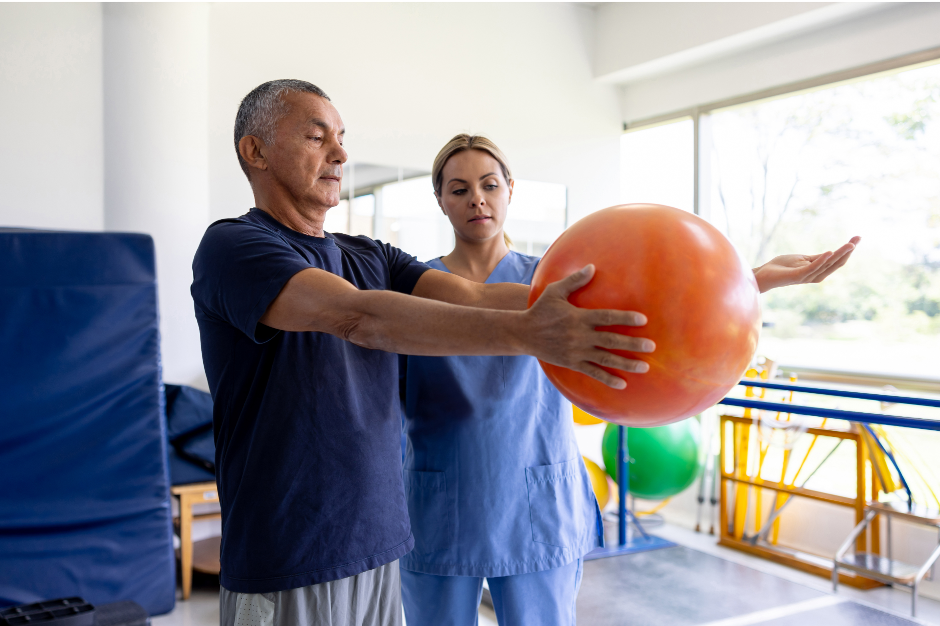 Older man with beard signing document, woman smiles beside him at a table.