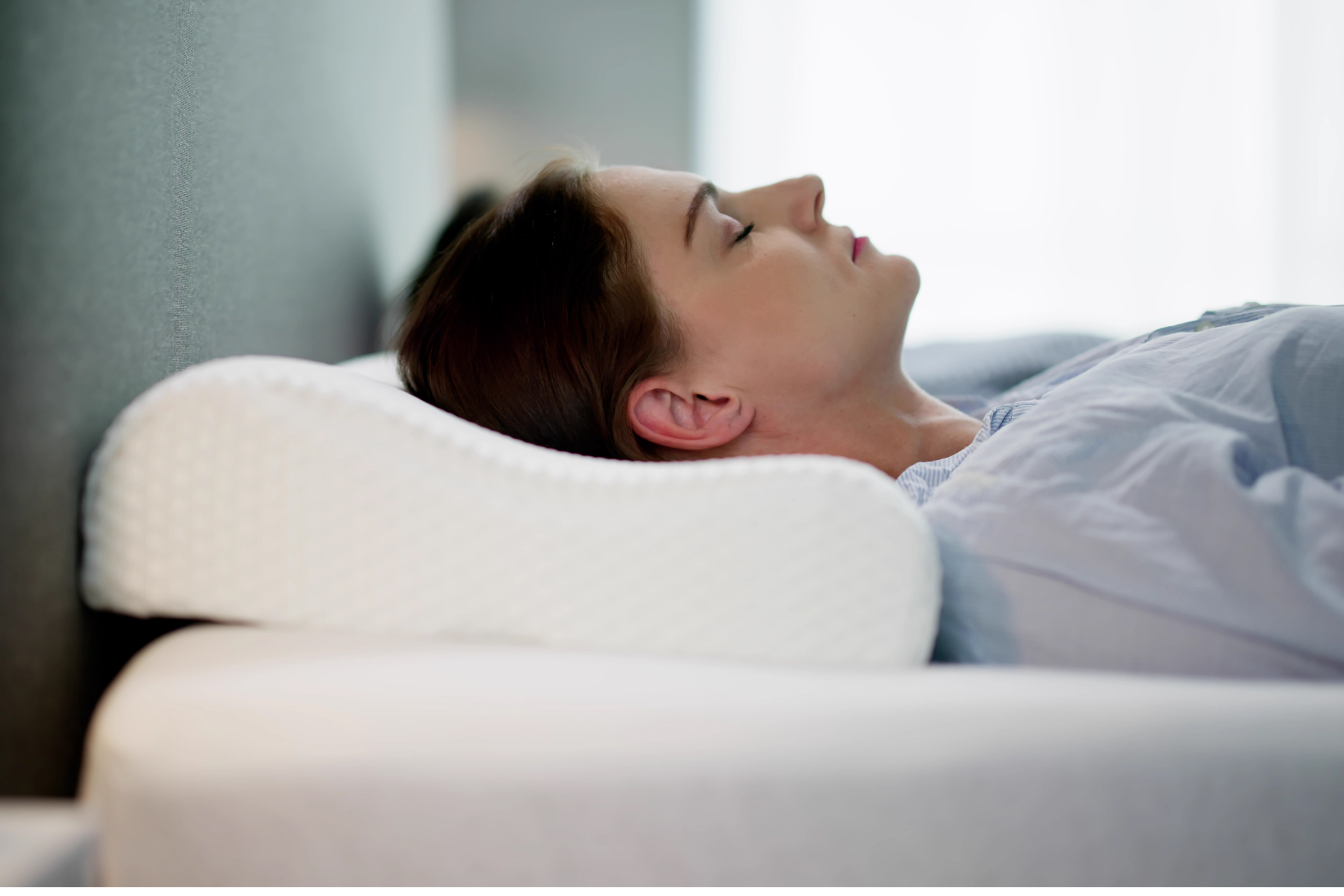 Older man with beard signing document, woman smiles beside him at a table.