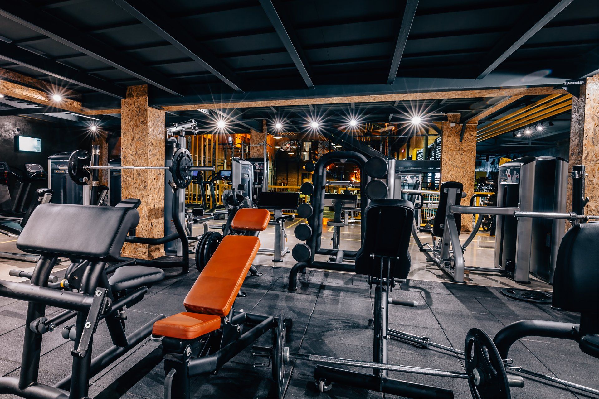 a gym filled with lots of exercise equipment and a bench .