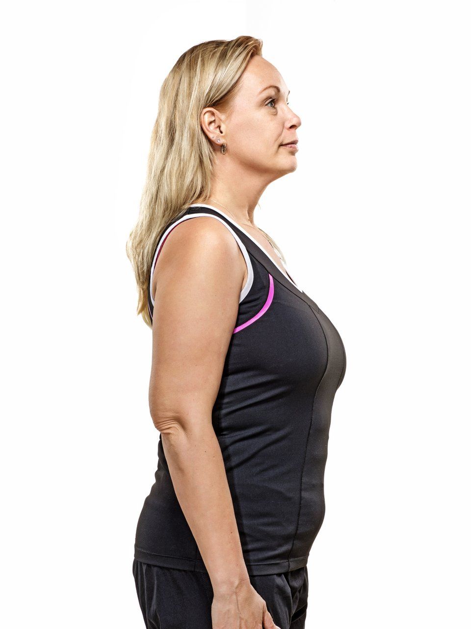 a woman in a black tank top is standing in front of a white background .