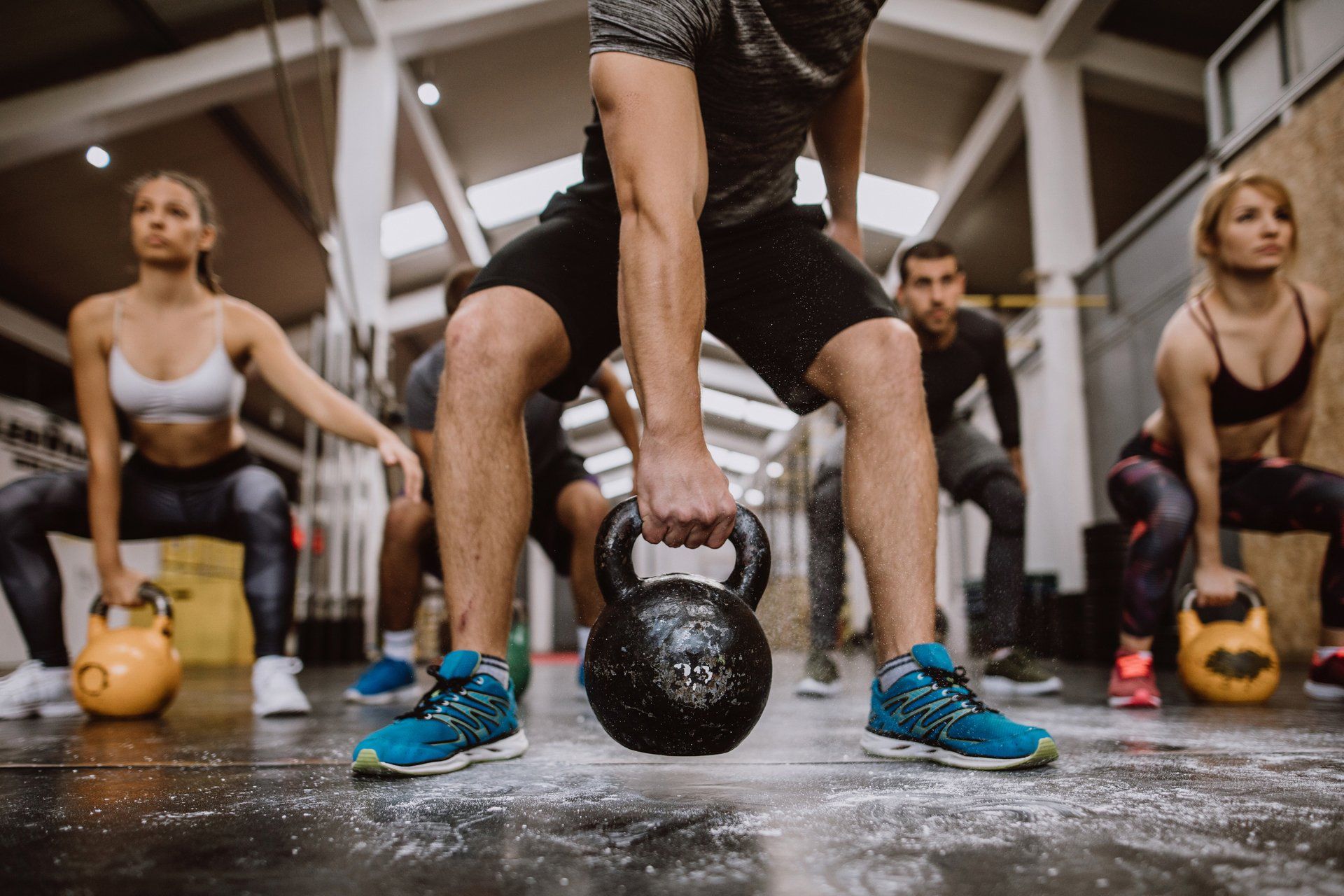 a man is lifting a kettlebell in a gym .