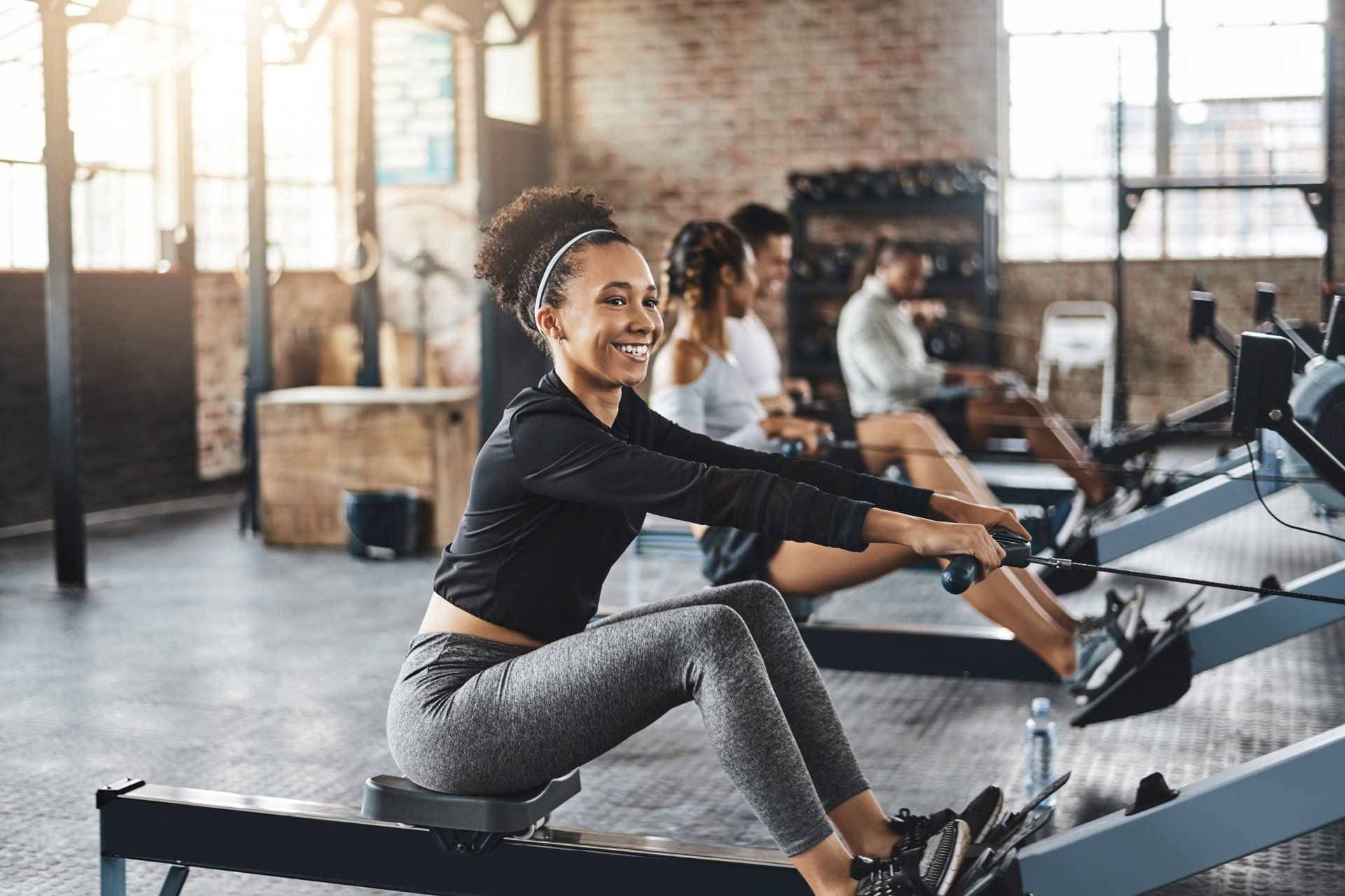 a woman is riding a rowing machine in a gym .