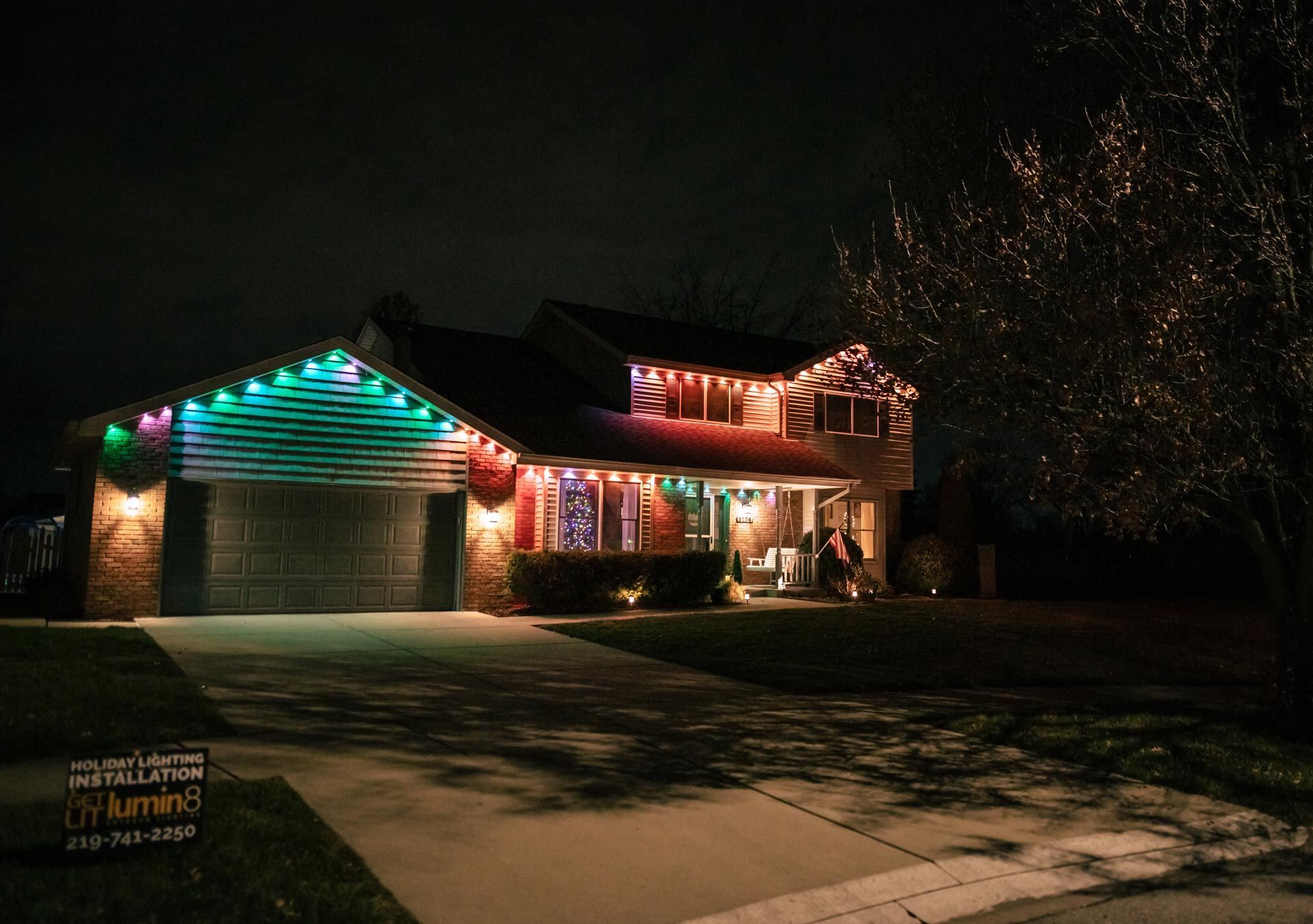 A house is decorated with christmas lights at night.