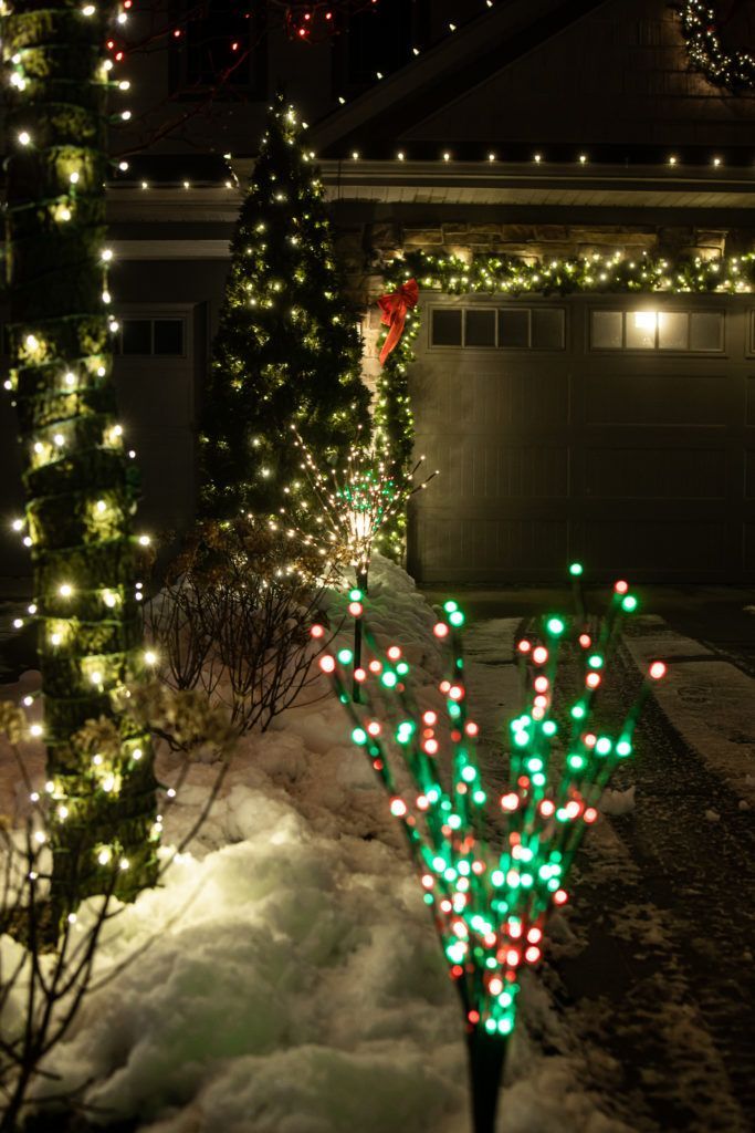 A row of christmas lights are lined up in front of a house.