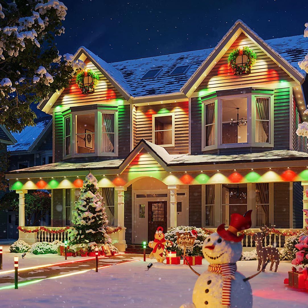 A house decorated for christmas with a snowman in front of it