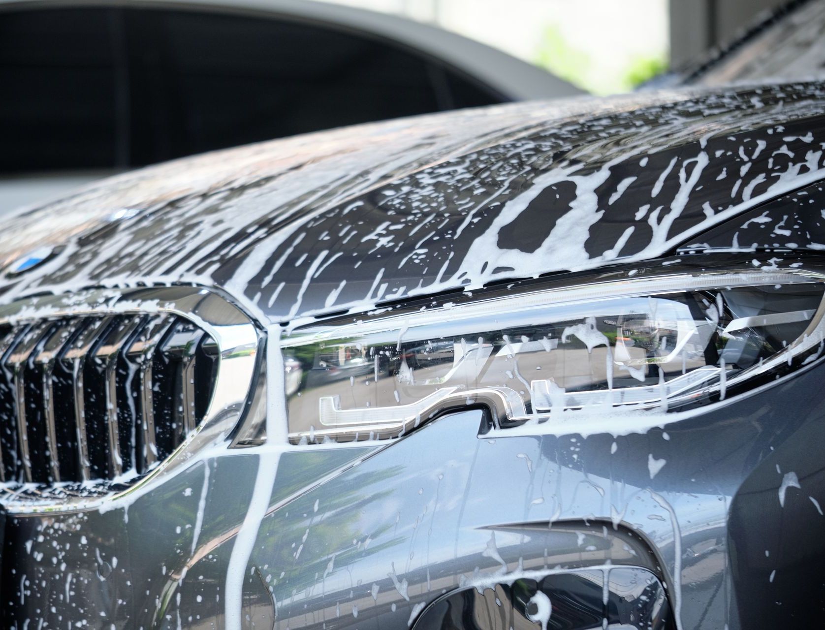 A person is cleaning the inside of a car door with a brush.